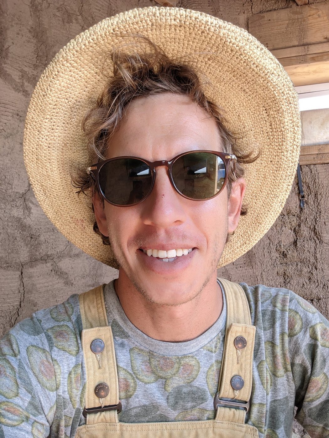 John Paul Garland wearing a straw hat and work overalls